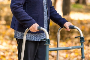 image waist down an elderly woman using a walker outside