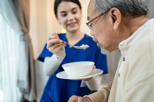 nurse feeding resident from a bowl