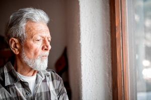 elderly man with dementia staring out window