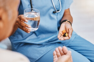 nursing home staff giving medication to a resident