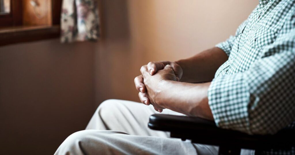 older man in wheelchair in dark room