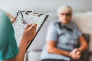 stock image of a health inspector questioning an elderly nursing home resident