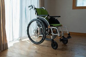 wheelchair in room by drapes