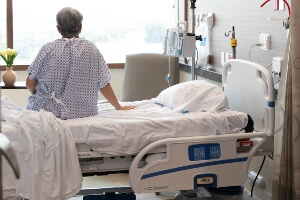 elderly female nursing home resident sitting on the edge of the bed