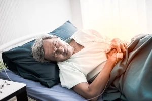 Men laying down in a bed.